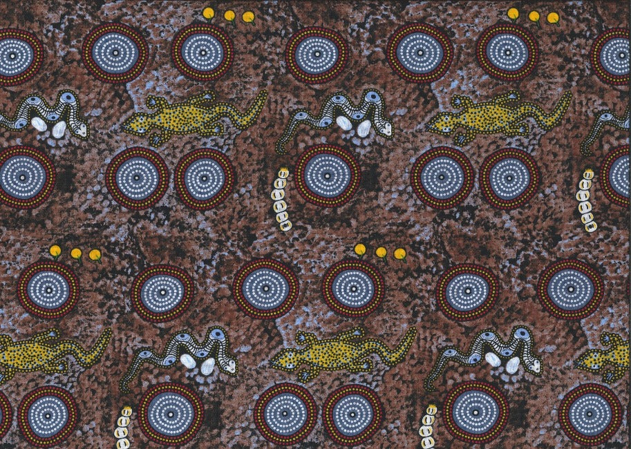 Snake Goanna Bush Tucker blue Australian fabric by Wally Evans is a quirky design, featuring goannas, snakes, berries and grubs in ecru, yellow and light blue on a brown and greybackground, with red and grey circles (water holes?) completing the picture.