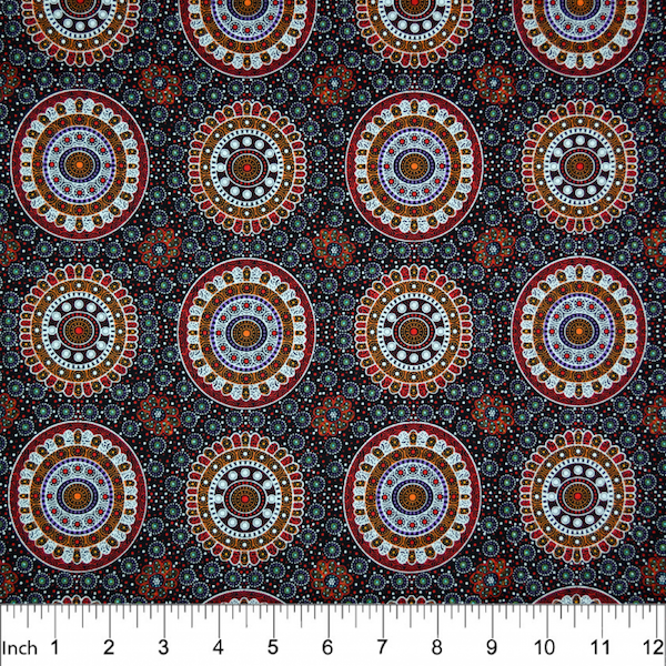 Alura Seed Dreaming Red Australian Aboriginal Fabric by Karen Bird depicts the Alura seeds arranged in circles, with decorations in tan, purple and white surrounding it. The design is printed on a black background