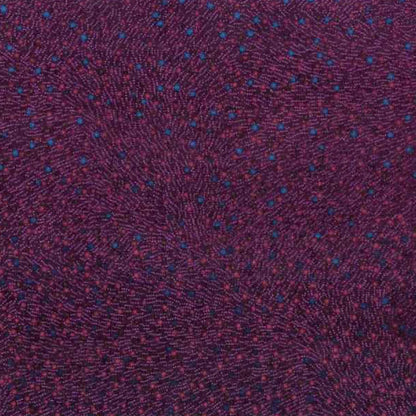 A close-up of a textured fabric with a dark purple base and a fine pattern of small blue and red dots.
