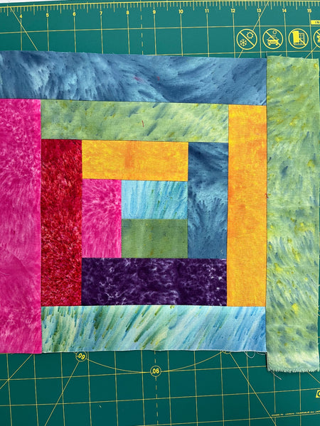 A Log Cabin Quilt block made with lots of colorful fabric strips