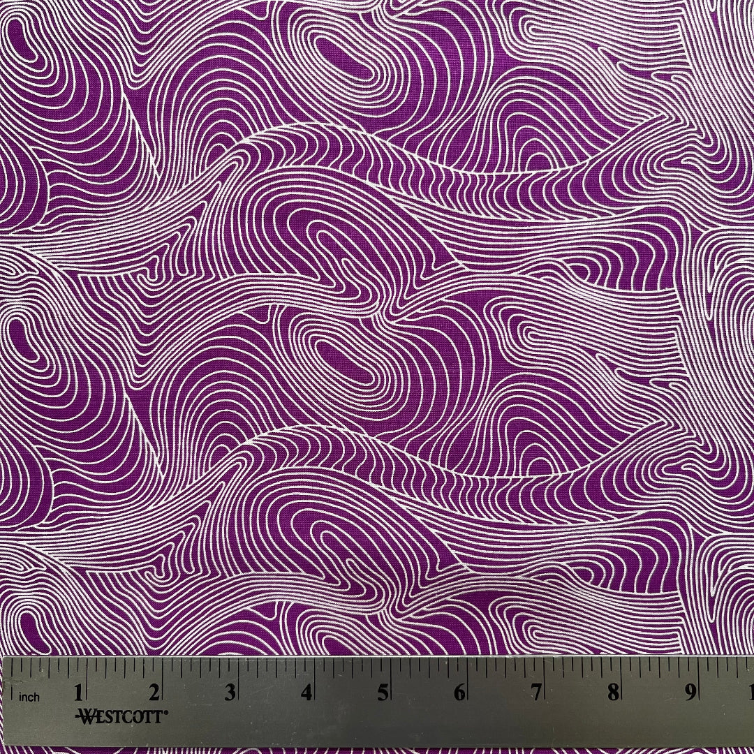 Fabric with purple and white wavy pattern, ruler at the bottom for scale.