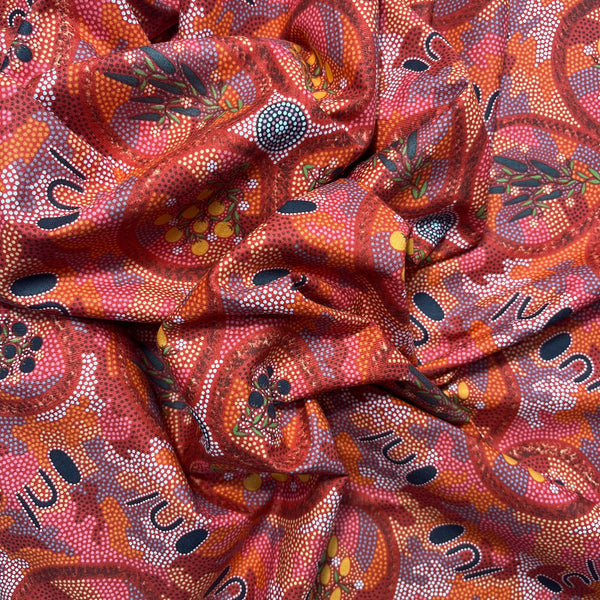 Textured fabric with abstract pattern in reds, browns, and blacks