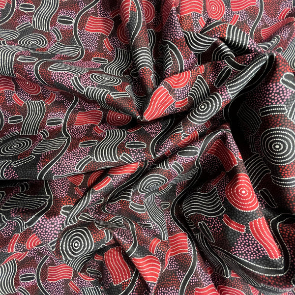 Textile with abstract pattern featuring red, black, and white 