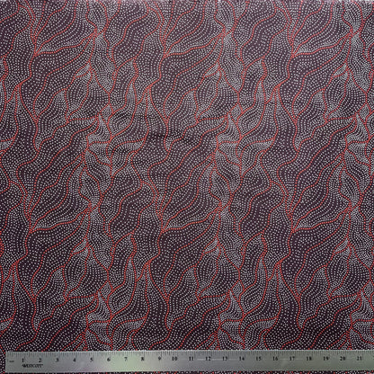 Textile with abstract pattern on a dark brown background, featuring a ruler at the bottom for scale.