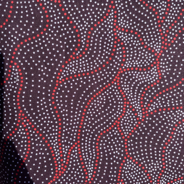 Close-up of fabric with red and white pattern on a dark background