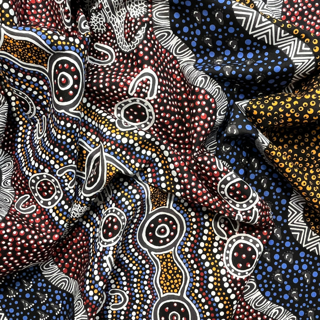 Heather's design portrays how the Goanna is hunting for its food in the Aboriginal Habitat, a black background with yellow, brick red and blue dots, and black and white decorations.