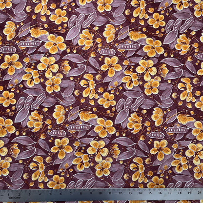 Floral pattern with yellow flowers and purple leaves on a brown background, with a ruler for scale.