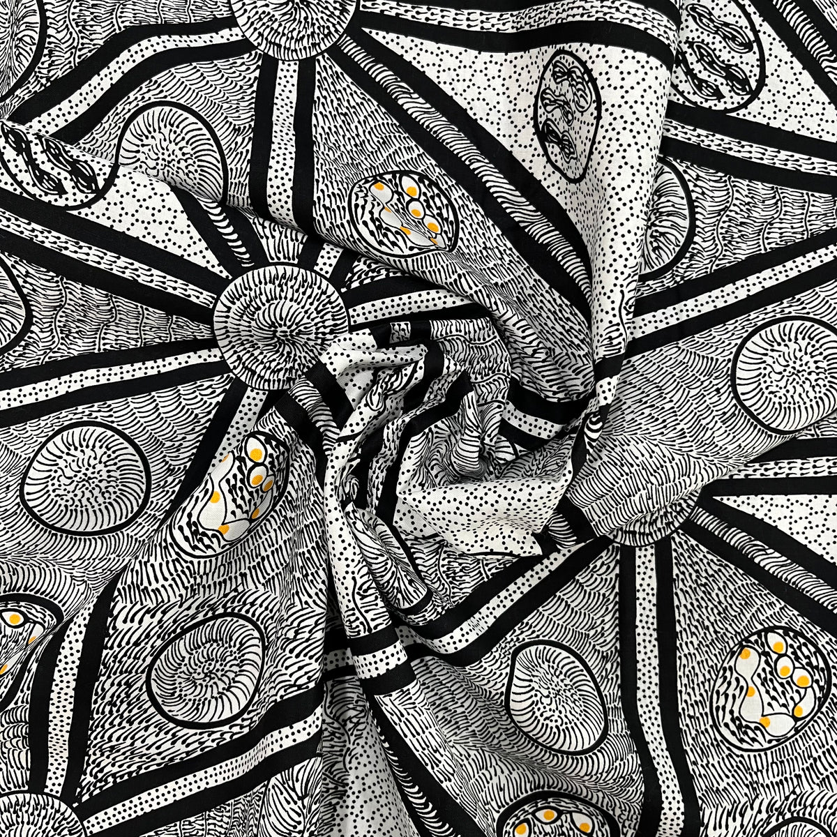 white, black and a tiny bit of yellow abstract design fabric, shown in a decorative swirl