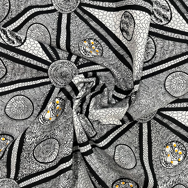 white, black and a tiny bit of yellow abstract design fabric, shown in a decorative swirl