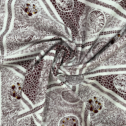A close-up of draped fabric with an intricate white and burgundy abstract pattern featuring swirls, dots, and organic line designs.