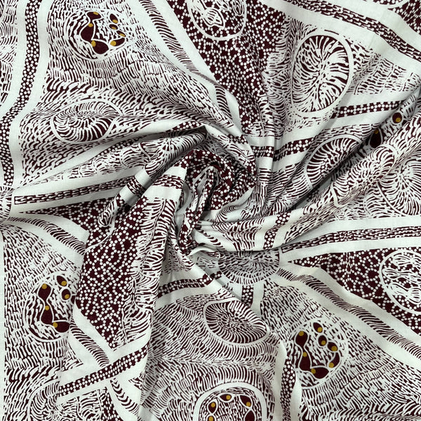 A close-up of draped fabric with an intricate white and burgundy abstract pattern featuring swirls, dots, and organic line designs.