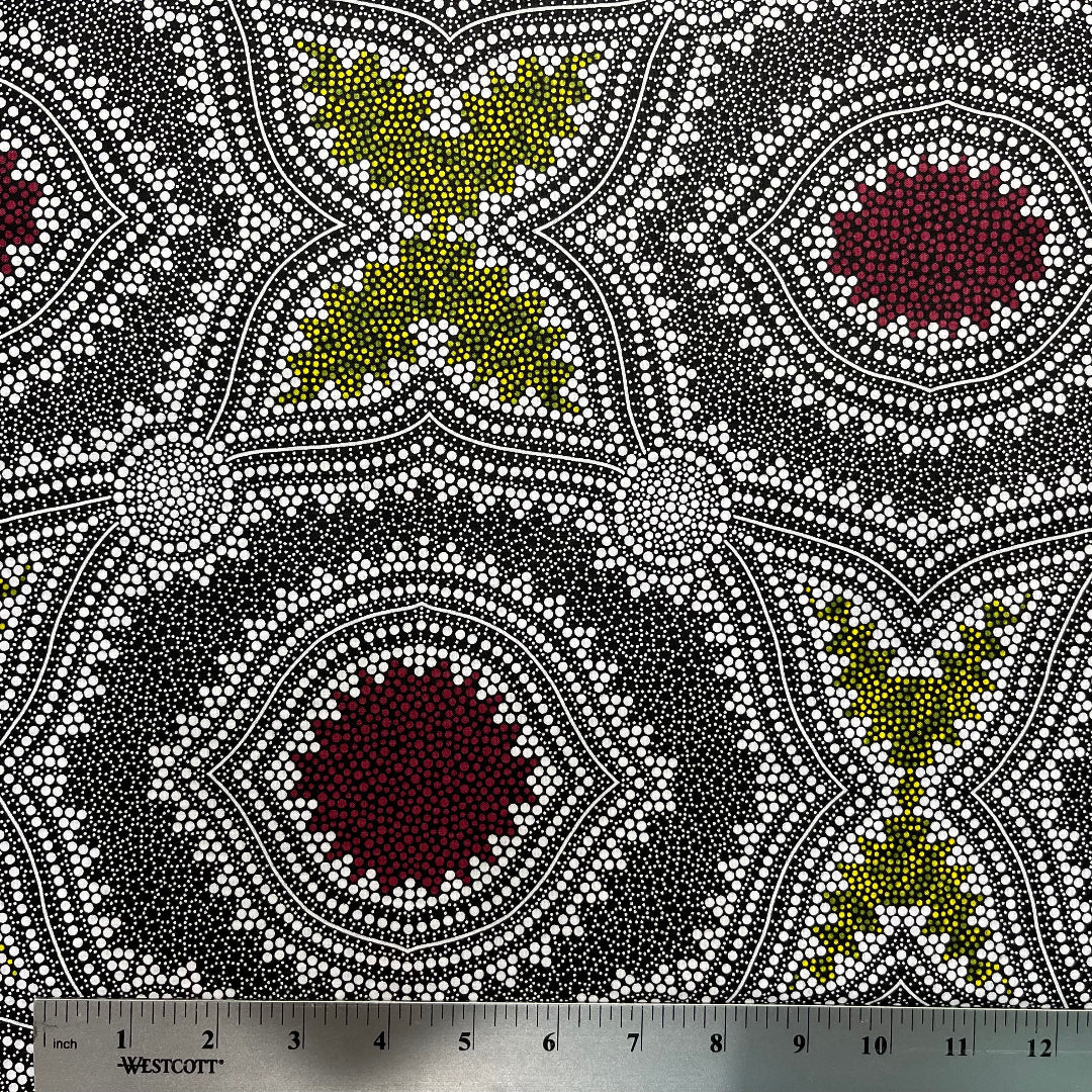 In this fabric, softly contrasting shades of grey, olive, burgundy, and white form patterns representing wind-scattered seeds and spinifex grasses—elements deeply rooted in desert life and culture.