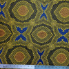 In this fabric, softly contrasting shades of gold, dark grey, blue and orange form patterns representing wind-scattered seeds and spinifex grasses—elements deeply rooted in desert life and culture.