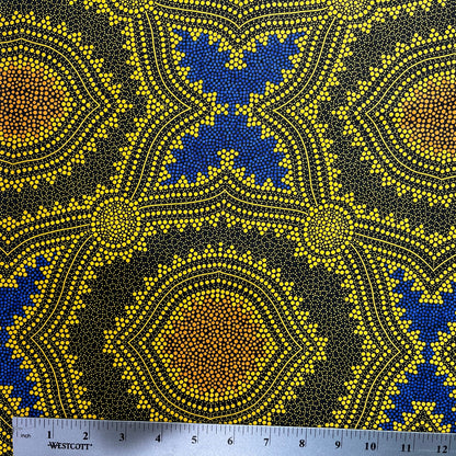 In this fabric, softly contrasting shades of gold, dark grey, blue and orange form patterns representing wind-scattered seeds and spinifex grasses—elements deeply rooted in desert life and culture.