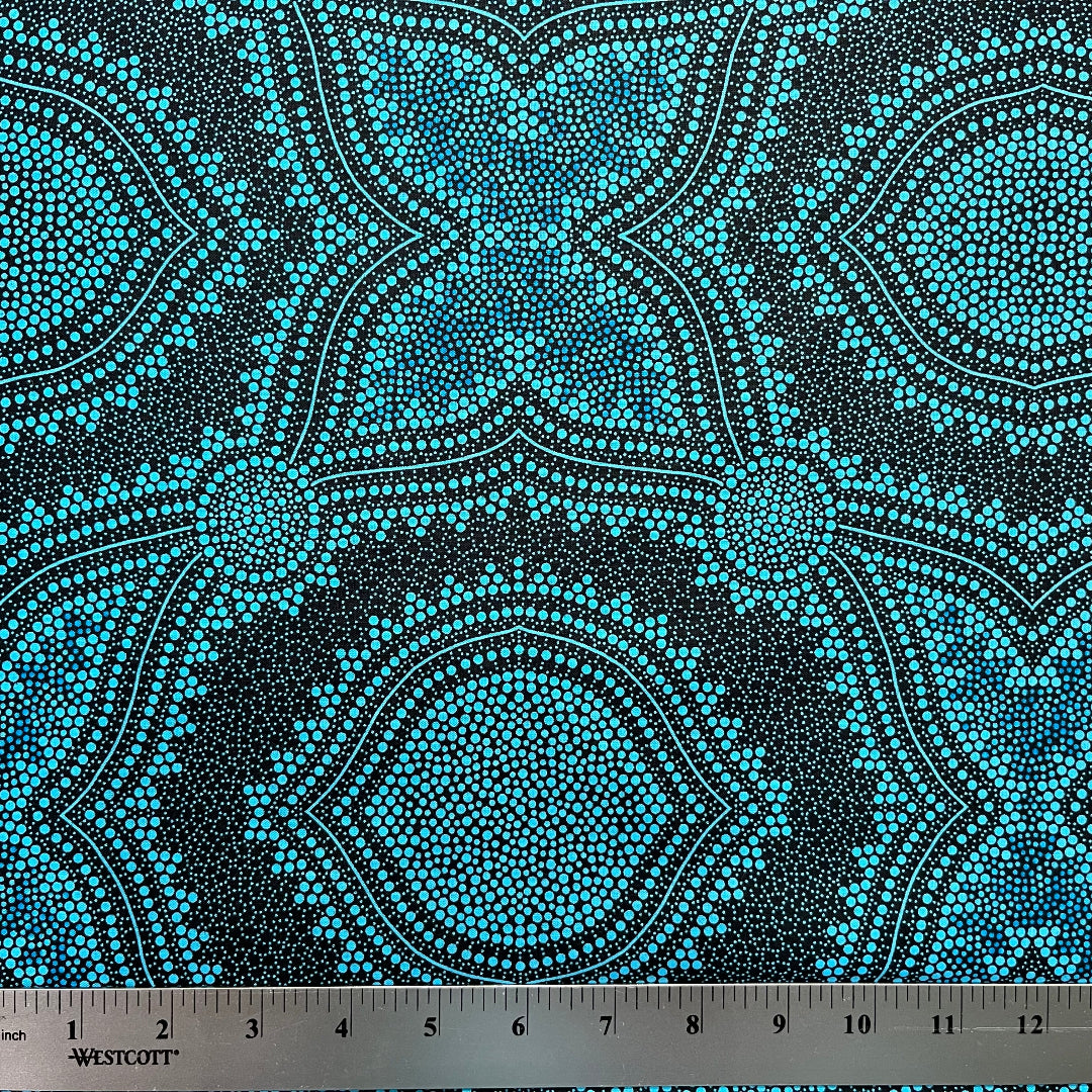 In this fabric, softly contrasting shades of sky blue, turquoise, black and white accents form patterns representing wind-scattered seeds and spinifex grasses—elements deeply rooted in desert life and culture.