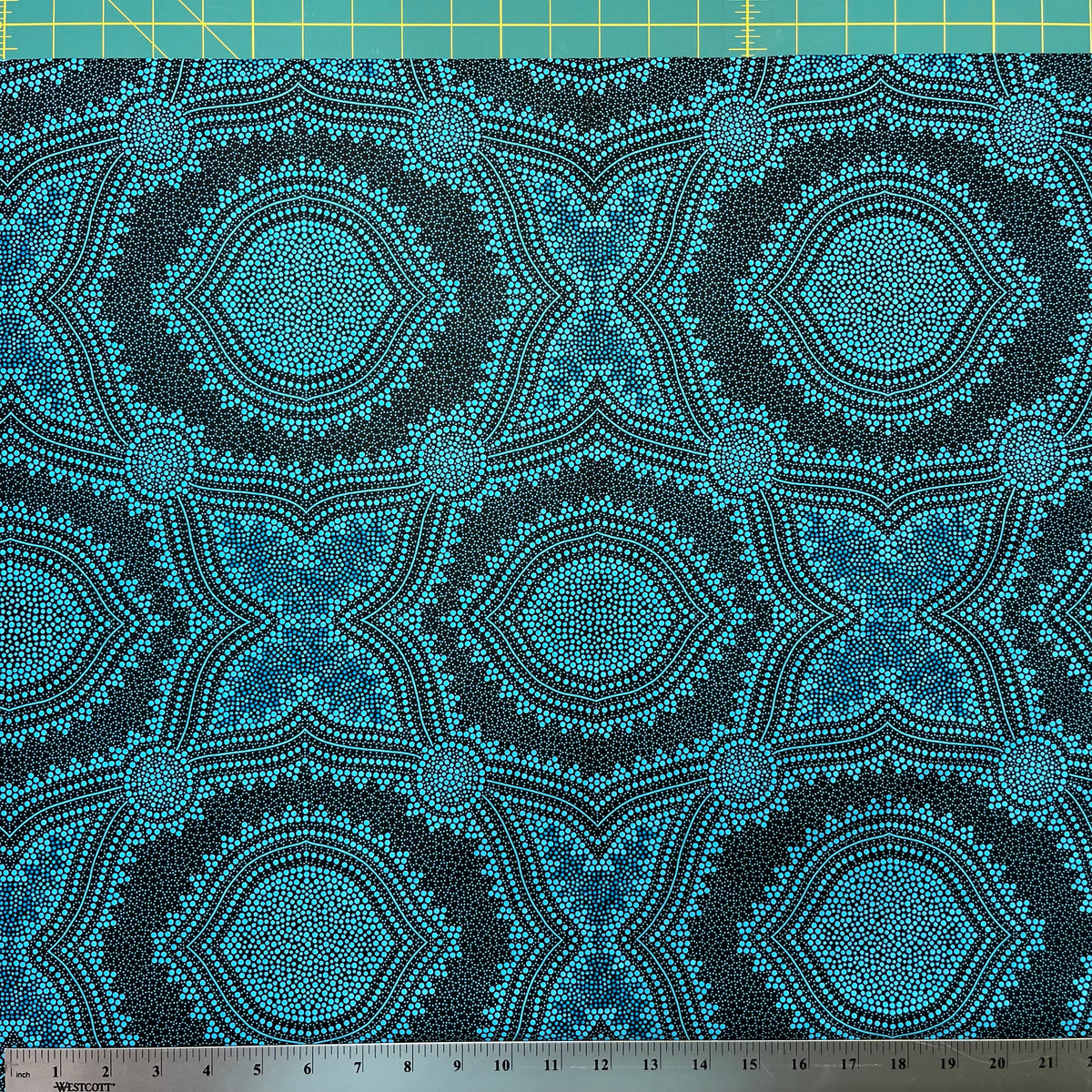 In this fabric, softly contrasting shades of sky blue, turquoise, black and white accents form patterns representing wind-scattered seeds and spinifex grasses—elements deeply rooted in desert life and culture.