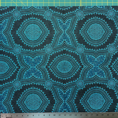 In this fabric, softly contrasting shades of sky blue, turquoise, black and white accents form patterns representing wind-scattered seeds and spinifex grasses—elements deeply rooted in desert life and culture.