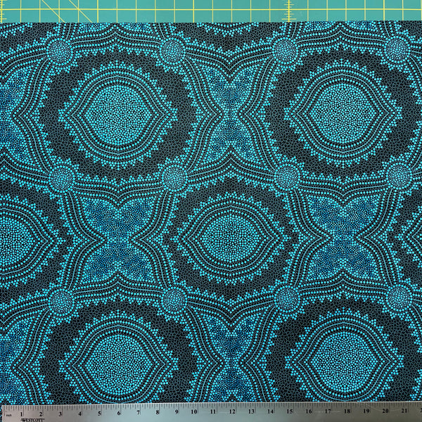 In this fabric, softly contrasting shades of sky blue, turquoise, black and white accents form patterns representing wind-scattered seeds and spinifex grasses—elements deeply rooted in desert life and culture.