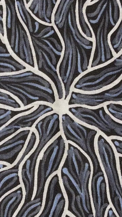 Running Water Dreaming grey is an intricate design of fine lines in white, grey and purplish grey on a black background, simulating the rivulets of water splashing from a central waterhole.