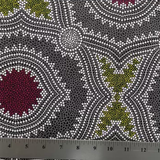 In this fabric, softly contrasting shades of grey, olive, burgundy, and white form patterns representing wind-scattered seeds and spinifex grasses—elements deeply rooted in desert life and culture.