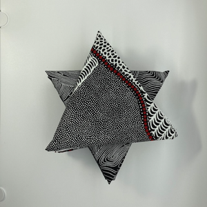 The picture shows a carefully curated selection of black, white and some red Australian Aboriginal fabrics, nicely arranged into a star.