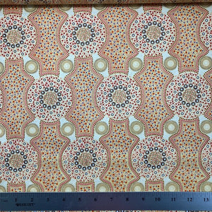 Bush Flowers  ecru Australian Aboriginal fabric is an intricate design depicting flowering bushes in vivid shades of orange, red, tan and yellow on an ecru background.